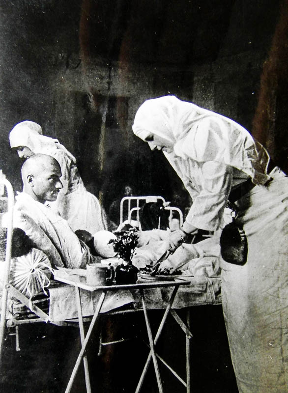 Regina Maria la căpătâiul unui rănit în 1917 <br /> Sursă foto: Arhivele Naționale ale României